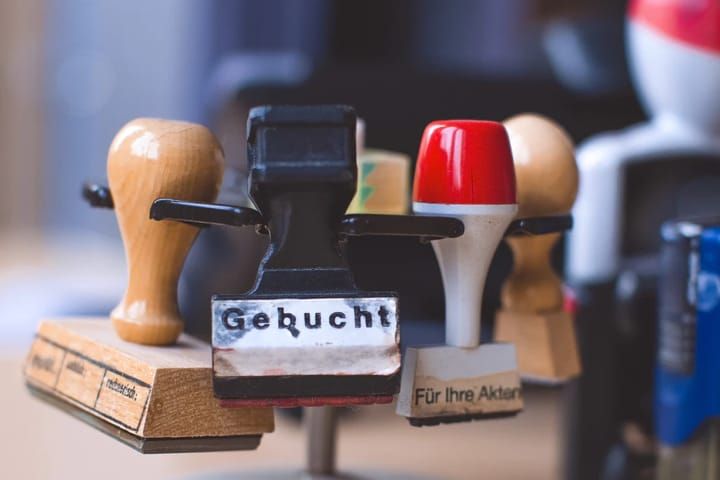 Verschillende stempels op elkaar gestapeld. Voorste stempel toont de tekst 'Gebucht'.