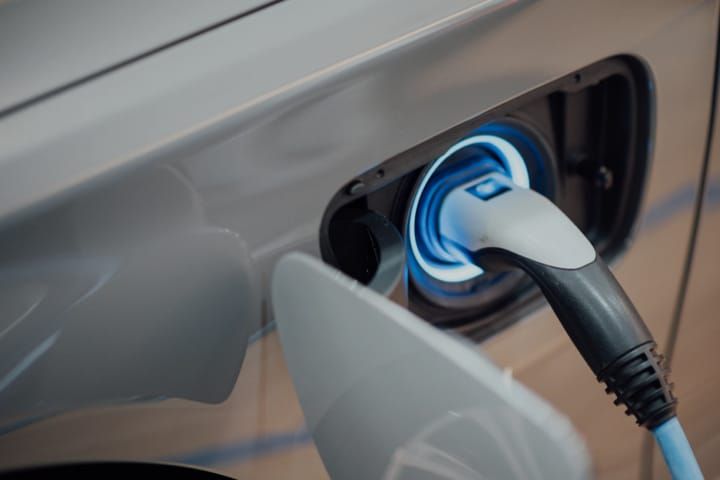 Elektrische auto wordt via een laadstation in een garage opgeladen, toont comfortabel en veilig laden thuis.